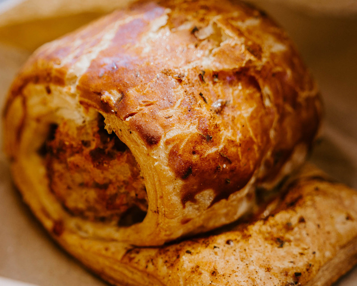 Close-up of a sausage roll with a soft focus background